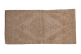 Distressed Oushak runner, subtle diamond medallion and vine motifs in neutral beige.