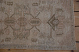 Close-up of distressed Turkish Oushak rug showing shadow style floral arabesques and intact side selvage.