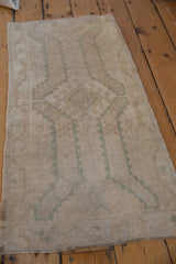 Angled perspective of a vintage Oushak rug mat showing the even wear across its hand-knotted pile.