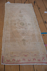 Vintage distressed Oushak runner showing even wear and soft cream, sand tones.