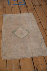 Distressed Oushak rug mat with subtle stepped medallion and pinwheel patterns.