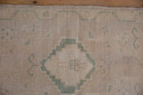 Hand-knotted pile of the distressed Oushak mat, with stepped dusty seafoam green patterns.