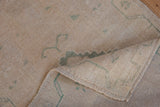 Distressed vintage Oushak rug pile, dusty seafoam green motifs, and intact side selvage.