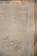 Distressed vintage Oushak rug with even pile wear, faint foundation, and intact side selvage.
