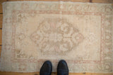 Even wear across the distressed vintage Oushak rug, showing its faded medallion and sand palette.