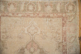 Even wear across the knot heads of a vintage Oushak rug in beige, sand, and mauve tones.