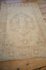 Soft, distressed texture of a vintage Oushak rug's low pile seen from a low angle.