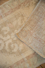 The hand-knotted foundation and secured side selvage of a distressed vintage Oushak rug.