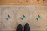 Distressed Oushak rug mat showing geometric turquoise medallion and aged ivory pile.