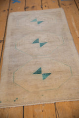 Distressed Oushak rug pile with primitive geometric medallion in pale dusty turquoise green.