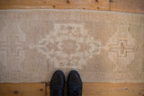 Distressed texture of the Oushak runner, with muted beige and subtle green patterns.