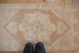 Distressed Oushak rug mat with pale copper and ivory roundel medallion showing even wear.