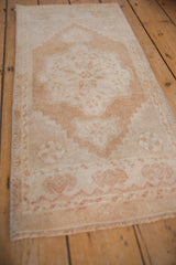Distressed vintage Oushak rug mat showing faded neutral tones and soft texture.