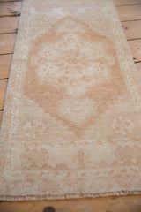 Textured distressed Oushak rug pile showing even wear in pale copper and antique ivory.