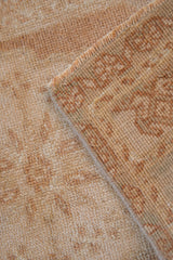 Worn hand-knotted pile and secured side of distressed Oushak rug.