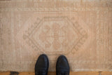 Distressed vintage Oushak rug mat texture, even wear to knot heads, beige and sand tones.