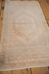 Vintage distressed Oushak rug mat, showing intact side cord selvage and faded pile texture.