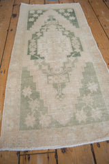 Distressed vintage Oushak rug: geometric pale green pattern with worn pile texture.