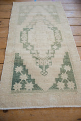 Vintage distressed Oushak rug corner with stepped geometric pattern in dusty emerald green.