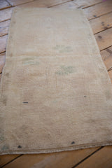 Distressed Oushak rug pile texture with even wear and faint dusty seafoam green motifs.