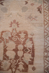 Distressed Oushak rug with dusty copper planter, oxidized silver tendrils, and cream field.