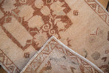 Distressed vintage Oushak rug pile in beige and dusty copper, with an intact side cord.