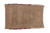 Distressed Oushak rug mat in worn beige with a faint diamond medallion and red-trimmed ends.