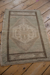 Distressed Oushak rug's hexagonal medallion, germinating blossom finials, dusty seafoam green and ivory.