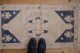Close-up of vintage distressed Oushak rug, showing low pile with visible foundation.