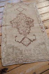 Vintage Distressed Oushak rug with brown geometric medallion and worn cream pile texture.