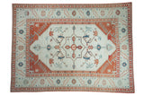 Distressed Oushak carpet with a diamond medallion in terracotta and powder blue on a softly worn ivory field.