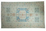 Distressed Oushak carpet with an oversized geometric medallion in sky blue, terracotta, and antique ivory.