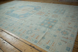 Geometric motifs in sky blue and terracotta on the even, worn pile of a vintage Oushak.