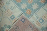 Hand-knotted construction of a vintage Turkish Oushak, showing the reverse weave and low-pile front.