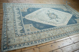 High-angle view of the Oushak rug's shadow medallion and geometric boteh border design.