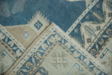 Hand-knotted foundation and geometric border of a vintage Oushak rug at the folded corner.