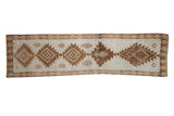 Vintage distressed Kars runner with a column of serrated brown medallions on an ivory field.