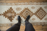 Short, even pile texture and serrated coffee brown medallions of a vintage Turkish Kars runner.