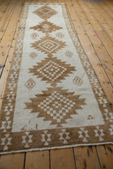Angled view down the length of a distressed Kars runner's geometric pattern.