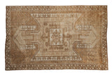 Distressed vintage Oushak rug, geometric shield medallion in ivory, beige, and coffee brown hues.