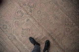Distressed vintage Oushak carpet with muted pink, silver, and beige lattice vinery.