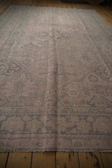 Distressed texture of Oushak rug showing muted pink, silver lattice vinery, and visible low pile.
