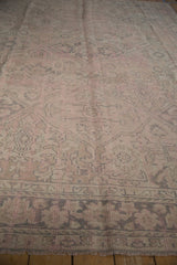 Distressed Oushak carpet's pale pink and ivory tones with muted geometric patterns and low pile.
