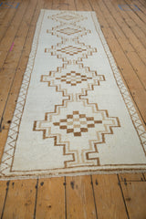 Perspective view of the vintage Kars runner's column of stepped medallions in brown tones.