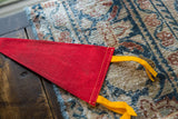 Textured red felt vintage pennant with yellow ties and stitched seam detail.