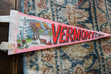 Close-up of the vintage Vermont felt flag's white stitched border and monument graphic.