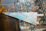 Reverse of vintage felt pennant showing pale blue-green hues, stitching, and visible stains.
