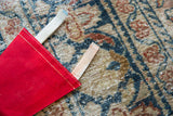 Close-up of the vintage felt pennant's red side seam with white stitching and ties.