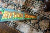 Vintage felt pennant, showing the tapered end of 'THRUWAY' in orange and green, with aged felt texture.