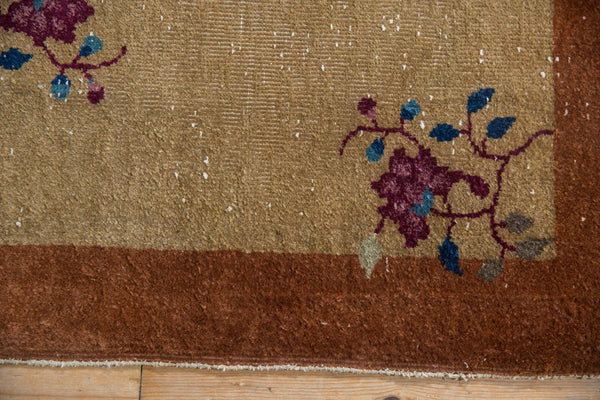 Detail of a vintage Nichols Art Deco rug showing mostly even pile wear and floral vinery.